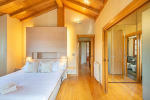 um quarto com uma grande cama branca e um banheiro em Espectacular casa con piscina próxima a Pamplona em Zizur Mayor mais 40 fotografias