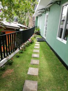 a walkway leading to a green house with a window at Roo Heaven Villas in Haputale