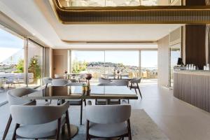 a restaurant with tables and chairs and a large window at Lisbon Chiado Hotel & Spa in Lisbon