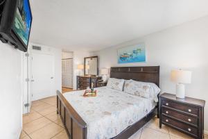 a bedroom with a bed and a flat screen tv at Pleasant condo with spectacular views, pools and spas in Marco Island +36 photos