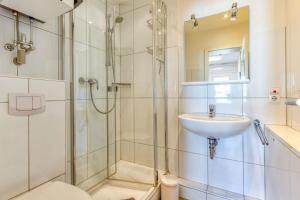 a bathroom with a shower and a sink and a toilet at Alte Teestube W 70 in Norderney