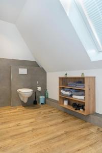 ein Bad mit einem Waschbecken und einem WC im Dachgeschoss in der Unterkunft Klosterhof Aue W 5 in Bad Zwischenahn