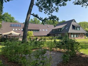 ein Haus mit einem Sonnendach auf einem Hof in der Unterkunft Klosterhof Aue W 5 in Bad Zwischenahn