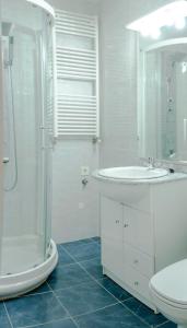 y baño blanco con lavabo y ducha. en Apartamento Los Colonia, en Burgos