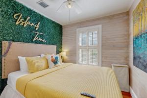 a bedroom with a bed with a yellow bedspread at The Headquarters in Key West +17 photos