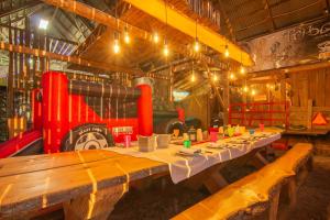 a long table in a barn with a train in the background at Domaine pour 21 pers avec SPA et GRANGE Festive in Saint-Justin