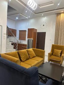 un soggiorno con un divano e due poltrone di Richmond Towne Home Apartmentt a Ibadan