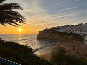 een uitzicht op een strand met zonsondergang bij CASINHA Do FAROL in Praia do Carvoeiro