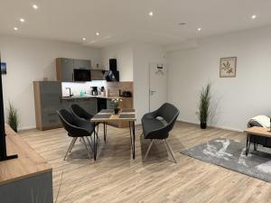 ein Wohnzimmer mit Tisch und Stühlen und eine Küche in der Unterkunft Klosterhof Aue W 14 in Bad Zwischenahn
