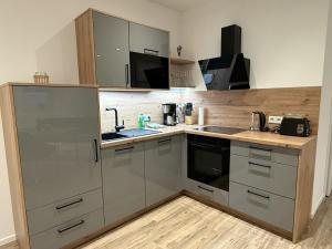 eine Küche mit Küchengeräten aus Edelstahl und Holzböden in der Unterkunft Klosterhof Aue W 14 in Bad Zwischenahn + 8 Fotos