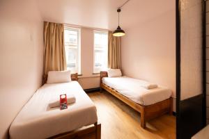 ein Zimmer mit zwei Betten und einem Fenster in der Unterkunft Malacuna Manchester in Manchester