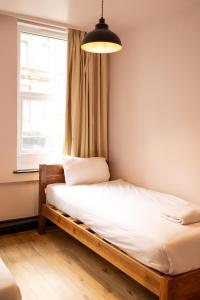 ein Bett in einem Zimmer mit Fenster in der Unterkunft Malacuna Manchester in Manchester + 70 Fotos