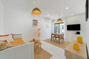 een woonkamer met een bank en een tafel bij CASINHA Do FAROL in Praia do Carvoeiro