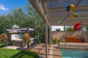 a backyard with a pool and a pergola with balloons at SPA vila na Golfe in Hrubá Borša