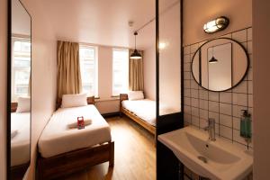 a bedroom with a bed and a sink and a mirror at Malacuna Manchester in Manchester