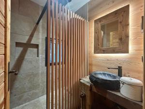 Chalet - Les Fermes de Céline - Barcelonnette في Enchastrayes: حمام مع حوض وجدار خشبي +42 صورة