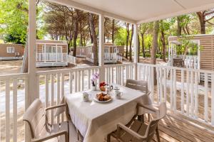 a table with a bowl of food on a porch at Club del Sole Adriano Family Collection in Punta Marina