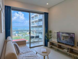 The Sóng OCEAN VIEW Apartment Vung Tau - Căn Hộ Du Lịch Bãi Sau Vũng Tàu - Linh House في فنغ تاو: غرفة معيشة مع أريكة ونافذة كبيرة