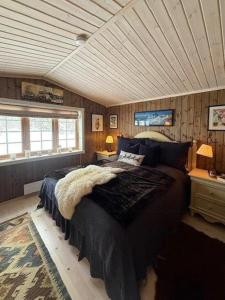 a bedroom with a bed in a room with wooden walls at Timber Cabin With Wood-Fired Hot Tub In Trysil in Granåsen