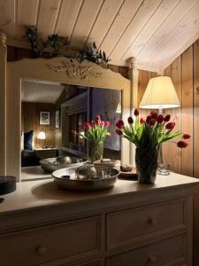 a counter with vases of flowers and a mirror at Timber Cabin With Wood-Fired Hot Tub In Trysil in Granåsen