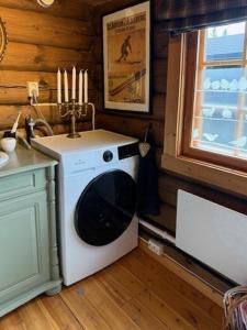 a kitchen with a washing machine in the corner at Timber Cabin With Wood-Fired Hot Tub In Trysil in Granåsen +21 photos