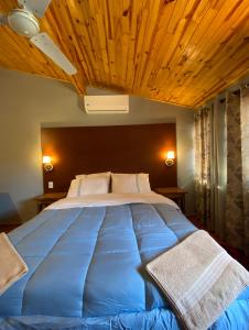 a bedroom with a large blue bed with a wooden ceiling at Hotel Solares in Barrio Caacupé Mí +65 photos