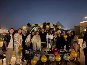 a group of people standing in front of a table with a pyramid at Giza Pyramids Inn in Cairo