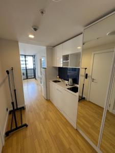 a kitchen with white cabinets and a wooden floor at Orbi city batumi new in Batumi