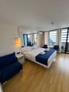 a bedroom with a large bed and a blue couch at Orbi city batumi new in Batumi