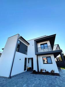 a white house with a large open door at Forest Lux Apartman in Odorheiu Secuiesc