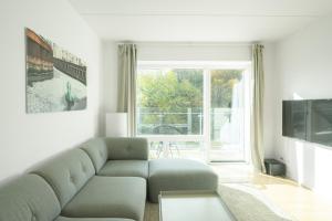 Una sala de estar con un sofá y una ventana grande. en Beautiful 1-BR w a balcony by Odense harbour - 82, en Odense