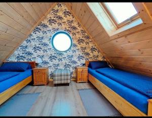 een kamer met 2 bedden op een zolder bij Domek w Borze in Kościelisko
