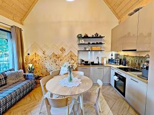 een keuken en woonkamer met een tafel en een bank bij Domek w Borze in Kościelisko
