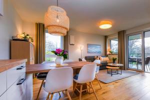 een keuken en woonkamer met een tafel en stoelen bij Salzbrise - Balkon, Sauna, Strandnah, Familienfreundlich in Kellenhusen