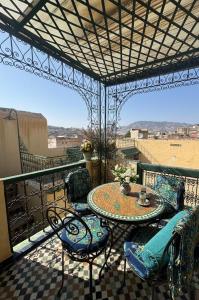 a patio with a table and chairs on a balcony at Riad Fez Panorama in Fès