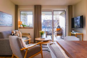 een woonkamer met een bank en een tafel bij Salzbrise - Balkon, Sauna, Strandnah, Familienfreundlich in Kellenhusen