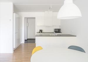 Una cocina blanca con gabinetes blancos y un fregadero. en Modern spacious 2-BR by Odense harbour - 91, en Odense