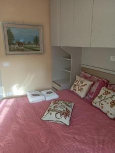 a bedroom with a pink bed with towels on it at Il Piccolo Borgo sul Lago in Rome