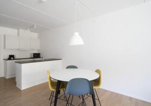 cocina blanca con mesa y sillas en Spacious 2-BR w a balcony by Odense harbour - 93, en Odense 7 fotos más