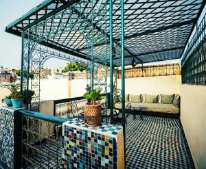 a screened porch with a couch on a balcony at Riad Fez Panorama in Fès