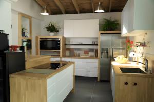 Una cocina con gabinetes blancos y un refrigerador negro. en Chambres D'hôtes Le Palmier, en Saint-Michel-Mont-Mercure 25 fotos más