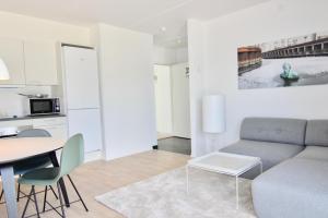 una sala de estar con un sofá y una mesa en Beautiful 1-BR w a balcony by Odense Harbour - 121, en Odense 3 fotos más