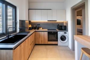 a kitchen with a sink and a washing machine at Paizan Homes - Kos City Center Apartments in Kos