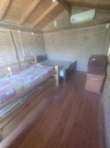 a bedroom with a bed and a wooden floor at Cabañas L' armonie in Bialet Massé