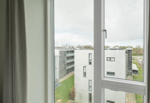 Una ventana abierta con vista a un edificio en Lovely 1-BR with a balcony by Odense Harbour - 259, en Odense