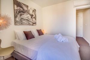 a bed room with a white bedspread and a painting on the wall at Chiado 44 in Lisbon