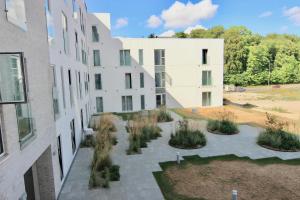 un edificio de apartamentos con un patio con plantas en Beautiful 2-BR w a balcony by Odense Harbour - 125, en Odense