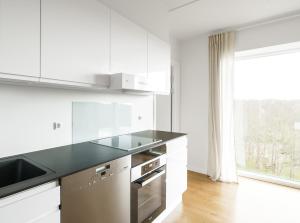 eine Küche mit weißen Schränken und einer schwarzen Arbeitsplatte in der Unterkunft Beautful 2-BR in DGBN Silver property - 315 in Hunderup