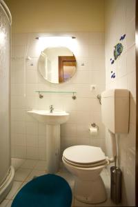 Un baño con inodoro, lavabo y espejo. en Αγία Κυριακή Traditional Guesthouse, en Ayía Kiriakí