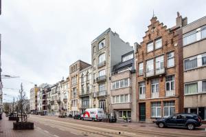 een straat met gebouwen en auto's op straat bij Bruges by the Beach in Blankenberge
